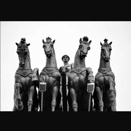 Fotografía escultura de cuatro caballos y una persona guiándoles