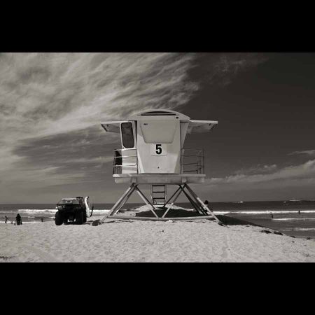 Foto en blanco y negro de una caseta en la playa con el numero 5